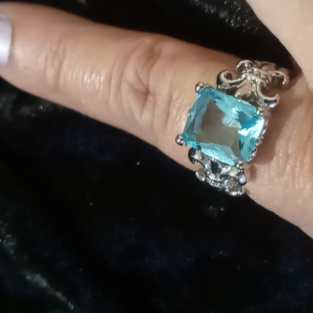 Aqua marine gem stone in 925 silver with Fleur De Lis accents on each side.
